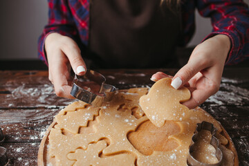 Baker cutting cookies of raw gingerbread dough
