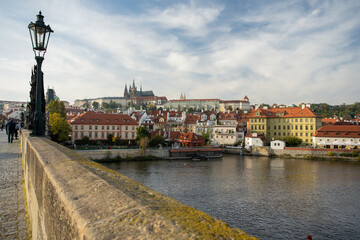 Vltava river and Prague Castle St. Vitus Cathedral and Charles Bridge in the center of Prague at sunset. there are reflections on the river surface and the sky is illuminated by the sun