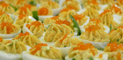 Plate of Russian eggs filled with yolk cream decorated with caviar