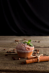 Christmas muffin with mint sprig and cinnamon on wooden background