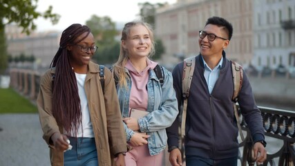 Diverse happy students walking outdoors and chatting during break - Powered by Adobe