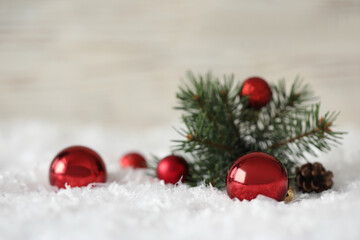 Obraz na płótnie Canvas Beautiful Christmas balls and fir branch on snow