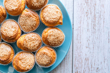 Close up top view on fresh homemade corn pone muffins in blue plate on wooden rustic table background with copy space