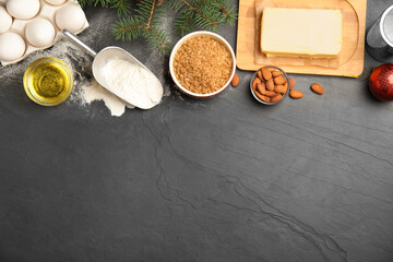 Flat lay composition with ingredients for traditional Christmas cake on grey table. Space for text