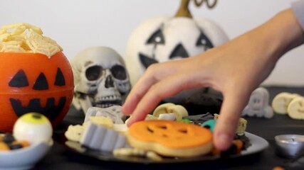 Taking halloween hot drink from festive table with snacks and treats
