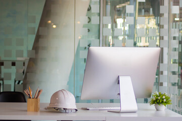 Close up view of engineer worktable with computer, safety helmet, stationery and copy space on...