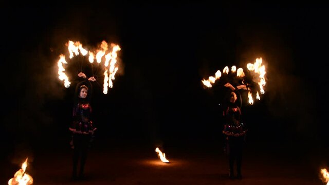 Beautiful two woman with fire poi perfomance outdoors