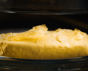 Cuchillo de metal en mantequilla con fondo negro, minimalista desayuno con pan