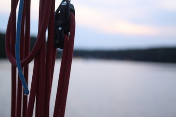 Liny i bloczki na żaglówce z widokiem na jezioro © Mikoaj