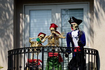 Fototapeta na wymiar Skeletons pirates on the balcony at home. Halloween scenery. Terrible holiday at home. Halloween in the USA. Traditions and house decor. Terrible creatures.