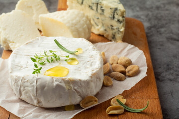 assorted cheeses on wooden board close-up.