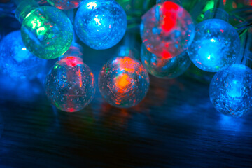 Beautiful Christmas garland glowing in the dark. Led holiday light bulbs with glass balls