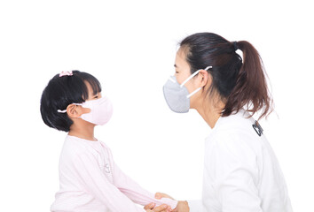 Mom wearing a mask and daughter wearing a mask kissing