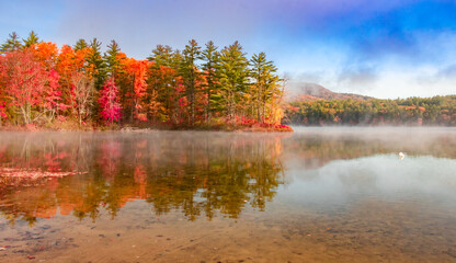 Awesome reflection of autumn lake on a misty morning