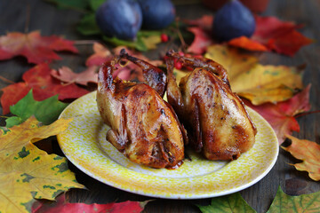 roasted quail stuffed with polenta with dried tomatoes, against the background of autumn leaves....