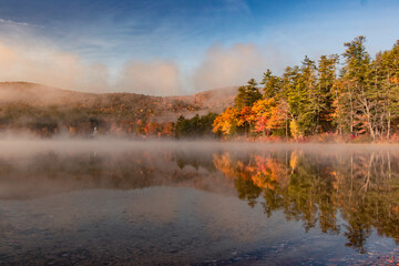 Awesome reflection of autumn lake on a misty morning