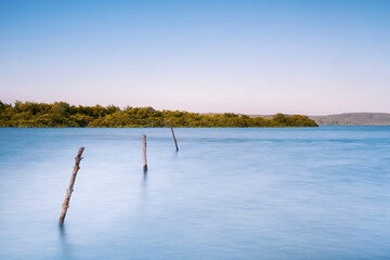 Long exposure in a bay at sunset with sea, mountains and sky. Blue color palette