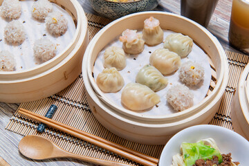 Steamed xiaolongbao and steamed dumplings served in a traditional steaming basket (.close up)