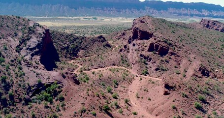 Aerial flight over valley in red buttes of Utah