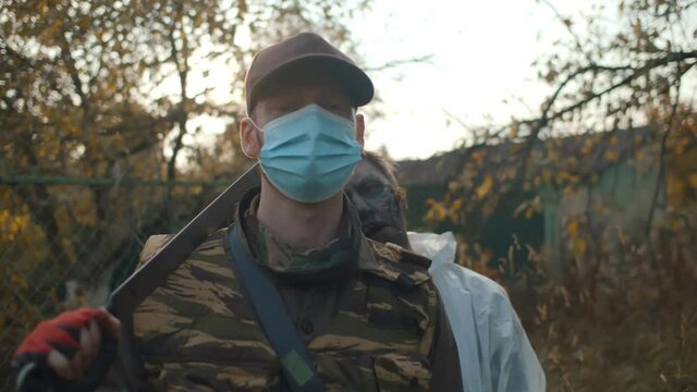 Portrait of zombie removing mask from man face and biting him