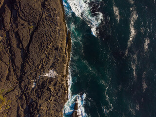 Aerial views of amazing waves tossing by rocks in the ocean. Wallpaper design. Fantastic landscape. Beauty of nature concept.