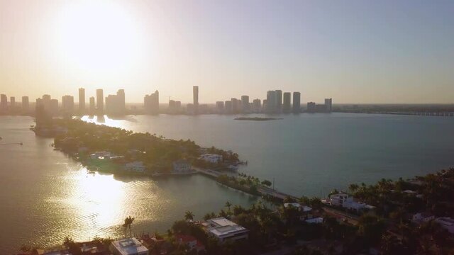 Aerial rising view overlooking the Biscayne and San Marco isles of the Venetian islands,,Town Square Miami skyline in the background, during sunrise in Florida - tracking, drone shot