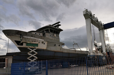 Cantiere navale navi in riparazione cielo nuvole scure cariche pioggia
