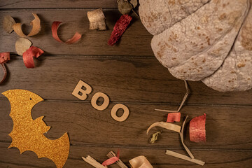 Halloween flat lay. Pumpkin, potpourri, orange bat, and Boo, word made from wooden letters on...