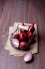 Raw red onions in a metal basket