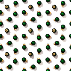 Seamless regular creative pattern with bright shiny little green Christmas balls isolated on white background. Printing on fabric, wrapping paper.