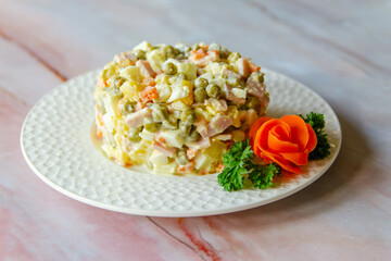 Traditional Russian festive salad Olivier (winter salad) on a white plate