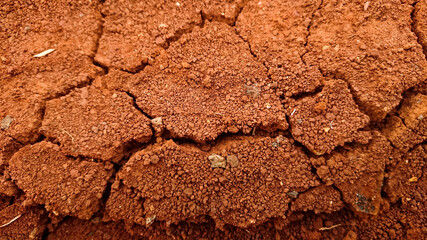 Textured background of cracked dry brown red earth. Cracked loose soil