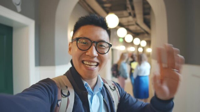 Asian male student filming video for internet blog about studying abroad