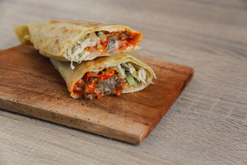 Delicious doner kebab wrapped in tortillas filled with chilli, meat, various vegetables and mayonnaise sauce