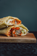 Close up of Delicious doner kebab wrapped in tortillas filled with chilli, meat, various vegetables and mayonnaise sauce