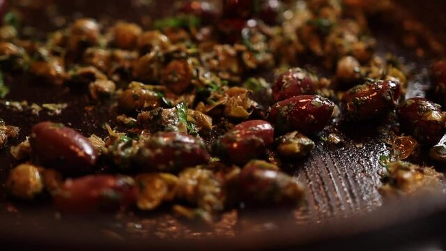 Close up shot of cooking Italian food in a pan with a wooden spoon