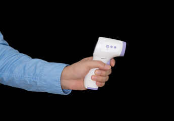 Holding infrared thermometer in front of black background