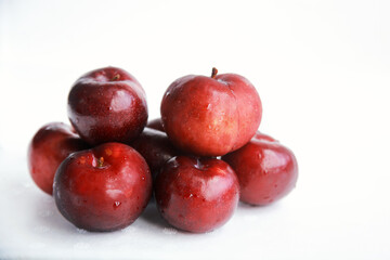 Pile of fresh juicy red plums isolated on white 
