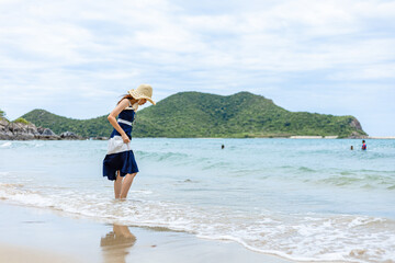 Fototapeta premium Happy young girl walking on the beach. Summer travel, vocation, holiday concept.