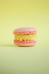 pink  korean macaroons with yellow cream on yellow background