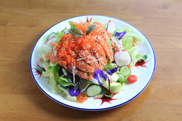 Salmon salad - smoked salmon and vegetables on wooden background