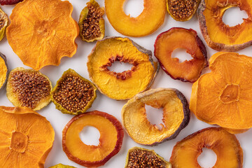 slices of dried persimmon, peach, plum and figs on a white background. dried fruits. eco.