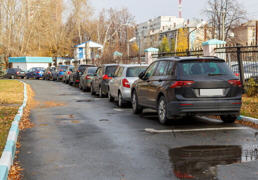 cars and crossovers in the city Parking lot near the fence. blurry focus