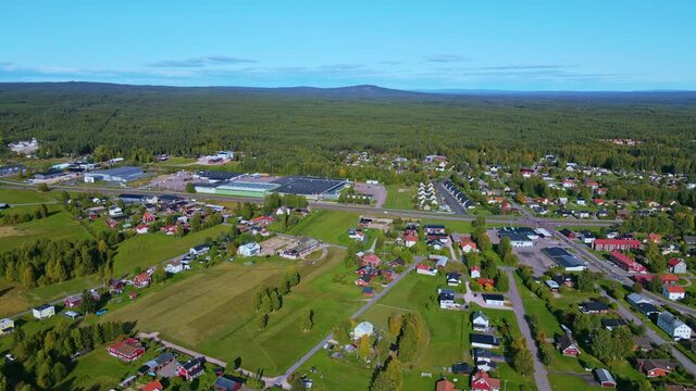 Typical Houses And Buildings At The Municipality Of Malung Overlooking The Dense Forest Under The Blue Sky In Dalarna, Sweden. - aerial drone shot