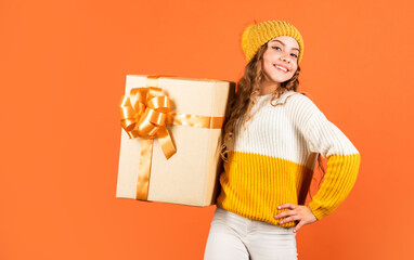 Find presents online. gift delivery service. shopping advantages. christmas is here. winter holiday surprise. girl knitted hat and sweater. kid hold present box orange background. happy new 2020 year