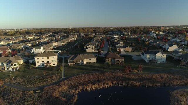 Aerial tracking shot of a quiet Midwestern neighborhood at sunrise.