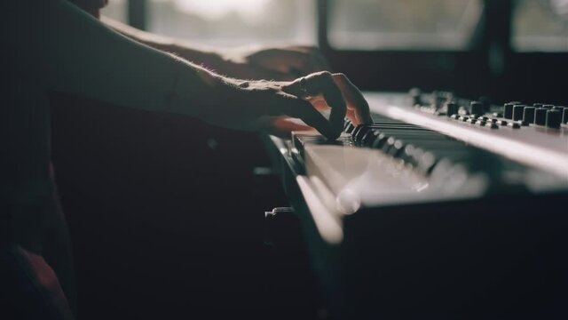 Hands are playing digital piano synthesizer. Professional pionist woman plays solo of music or creating a new melody