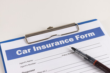 Car Insurance Claim	 Form or Auto Insurance Document and Pen at Right Frame and Clipboard on White Office Table