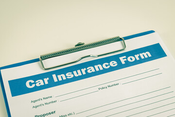 Obraz premium Car Insurance Claim Form or Auto Insurance Document on Left Slant and Clipboard on White Office Table in Vintage Tone 