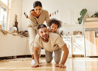 Happy multiracial family playing in kitchen.